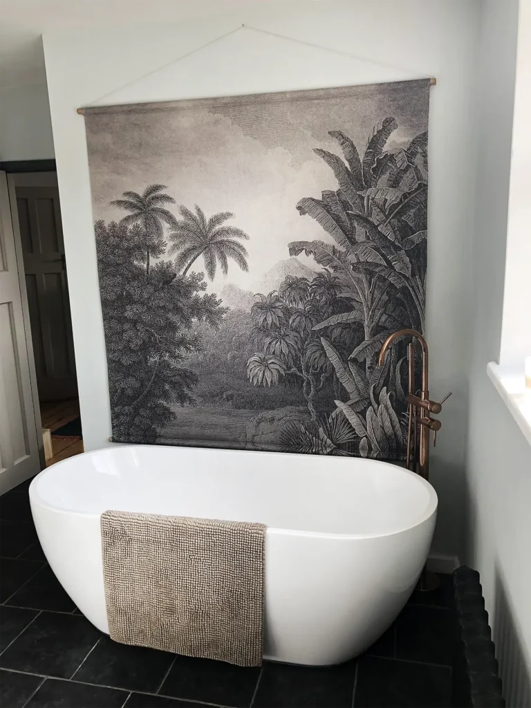 Freestanding bath with copper taps and large wall mural